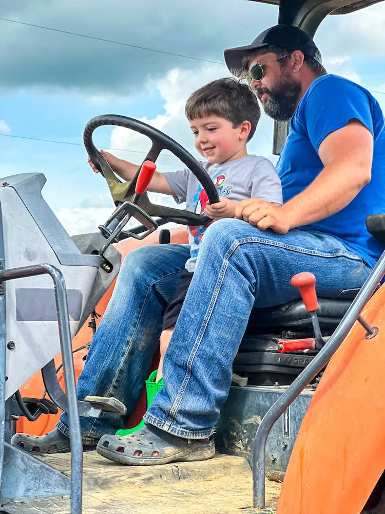 Orange tractor with black steering wheel and red-handled levers