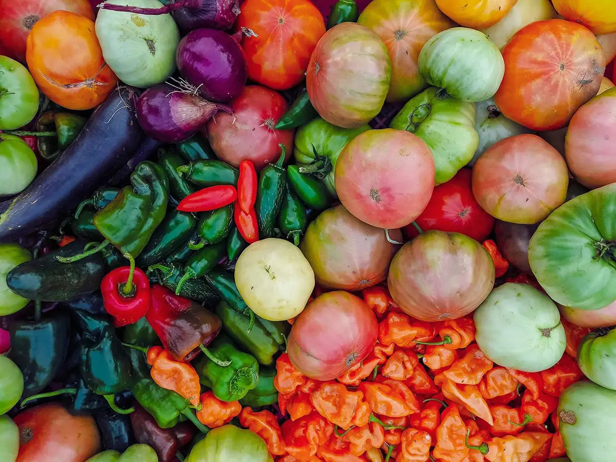A vibrant assortment of heirloom tomatoes in shades of red, green, and pink.